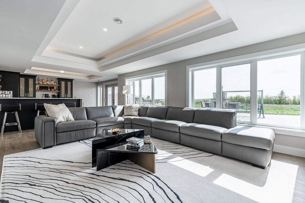 Axium-Interiors-Saskatoon-Finishing-Contractor-2023-DSC06974-HDR-walkout-basement-development Walkout basement with dark cabinetry and gold accents, bright and spacious with floor to ceiling windows